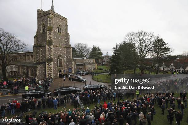 Family members and mourners look on as the hearse carrying the coffin of former England Football Team Manager Graham Taylor prepares to leave after...