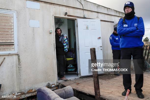 Israeli security forces stand outside a house as they evict a family of hardline Jewish settlers from the Amona outpost, a wildcat settlement...