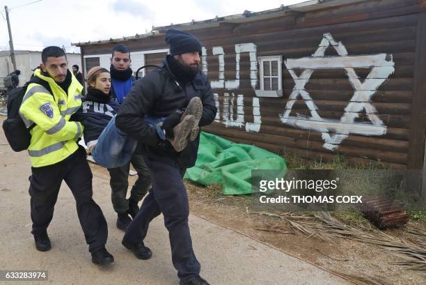 Israeli security forces carry a teenage hardline Jewish supporter of the Amona outpost northeast of Ramallah, as they evict settlers from the wildcat...