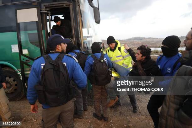 Israeli security forces carry a teenage Jewish towards a bus as they evict settlers from the wildcat Amona outpost, northeast of Ramallah, on...