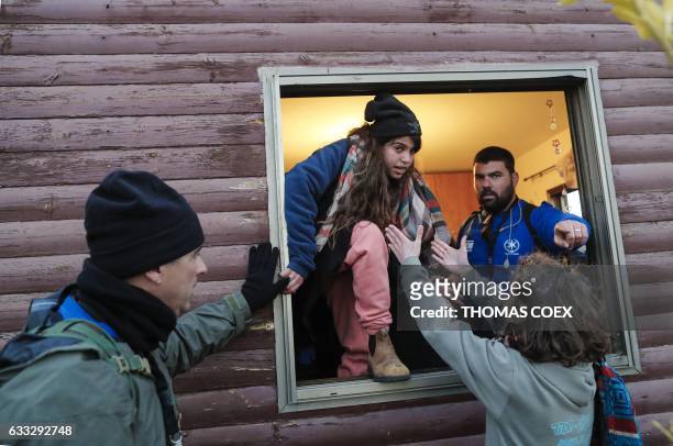 Young Jewish settler leaves a house from a window as Israeli security forces evict hardline residents from the wildcat Amona outpost, northeast of...