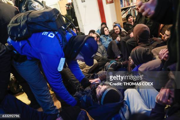 Jewish settlers lie on the floor as Israeli security forces evict hardline residents from the wildcat Amona outpost, northeast of Ramallah, on...