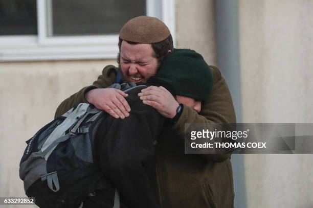 Two Jewish settlers embrace as Israeli security forces evict hardline residents from the wildcat Amona outpost, northeast of Ramallah, on February 1...