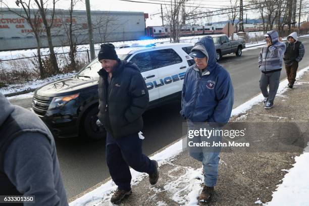 Police move immigrants towards an official day laborer pick-up site on February 1, 2017 in Stamford, Connecticut. The city of Stamford has an...