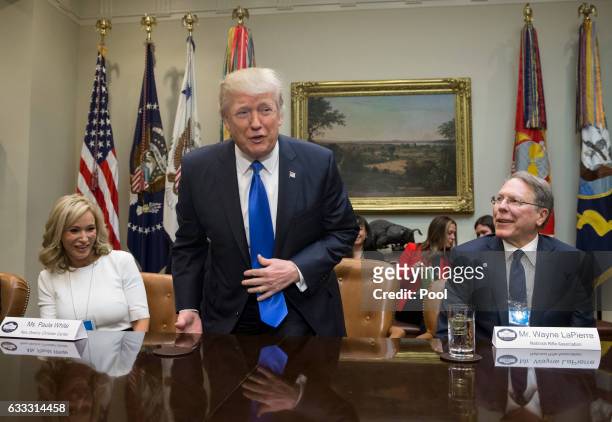 President Donald Trump takes his seat between Paula White of the New Destiny Christian Center and Executive Vice President and CEO of the National...