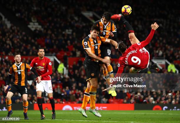 Zlatan Ibrahimovic of Manchester United performs an acrobatic kick with Harry Maguire and Andrea Ranocchia of Hull City during the Premier League...