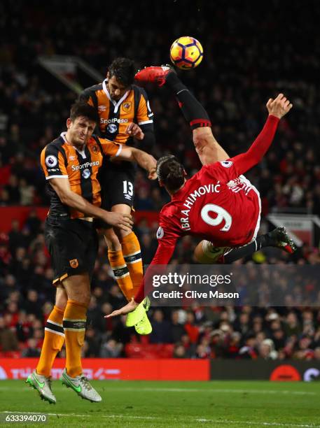 Zlatan Ibrahimovic of Manchester United performs an acrobatic kick with Harry Maguire and Andrea Ranocchia of Hull City during the Premier League...