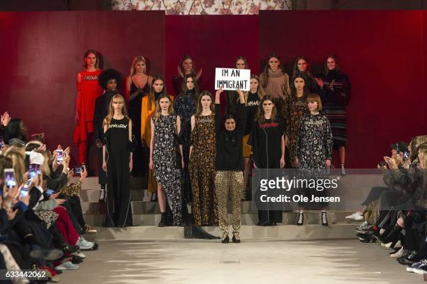 February 01: Leyla Piedayesh holds a sign saying 'I'm an Immigrant' at the end of her Lala Berlin show during the Copenhagen Fashion Week...