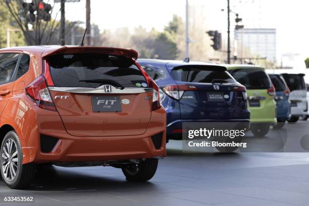 Honda Motor Co. Fit RS vehicle, left, and a Vezel Hybrid vehicle, second left, stand on display at one the company's showrooms in Tokyo, Japan, on...