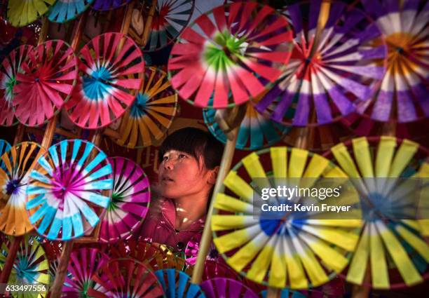 Chinese woman sells traditional handheld windmills at a local temple fair on the fifth day of the Chinese Lunar New Year on February 1, 2017 in...