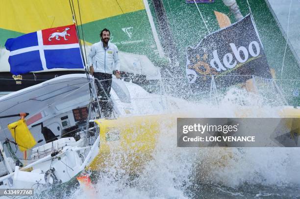 French skipper Louis Burton celebrates aboard his Imoca monohull "Bureau Vallee" as he crosses the finish line to place 7th in the Vendee Globe solo...