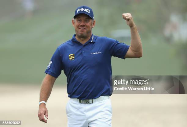 Lee Westwood of England smiles as he runs his ball through the bunker on the 10th hole onto the green during the first round of the Omega Dubai...