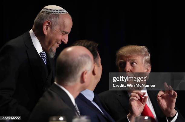 President Donald Trump speaks with members of the head table at the National Prayer Breakfast February 2, 2017 in Washington, DC. Every U.S....