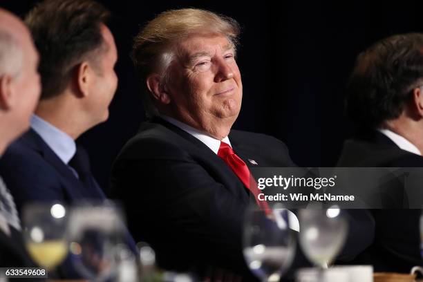 President Donald Trump listens as television producer Mark Burnett introduces him at the National Prayer Breakfast February 2, 2017 in Washington,...