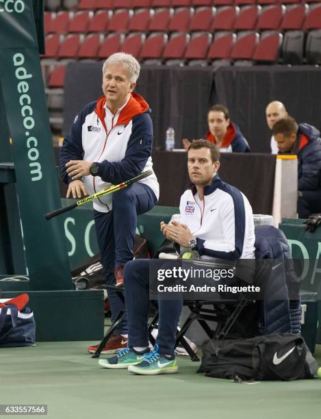 Coach Louis Cayer and captain Leon Smith of Great Britain look on during a doubles practice session prior to the Davis Cup World Group tie between...