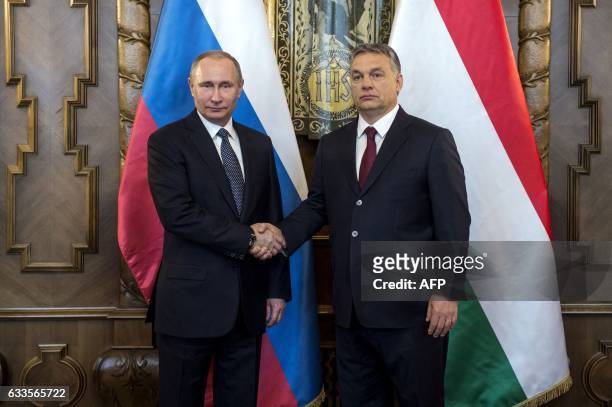 Russian President Vladimir Putin is welcomed by his host Hungarian Prime Minister Viktor Orban during his one-day visit, in the Hungarian parliament...