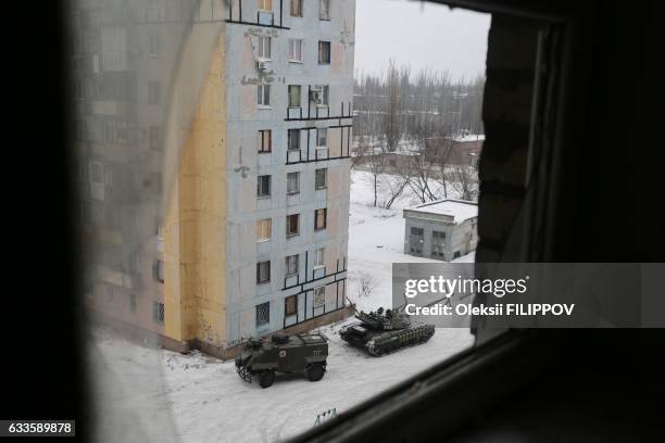 Tank and an armoured personnel carrier from the Ukrainian Forces are stationed outside a building in the flashpoint eastern town of Avdiivka that...