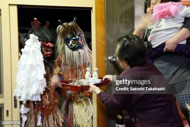 Namahage deities visiting a house during the Namahage festival of traditional folk event on New Year's Eve. They shouting loudly to people Are there...