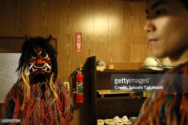 Young Namahage player who puts on a Namahage mask for the start of the Namahage festival of traditional folk event on New Year's Eve. This folk event...