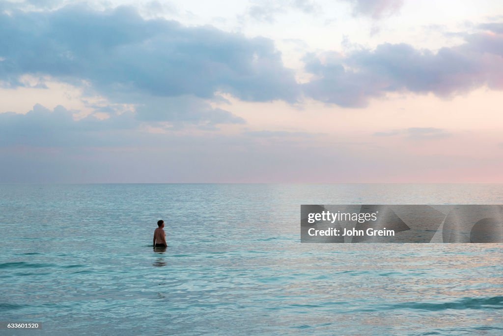 Solitary man in tropical ocean water...