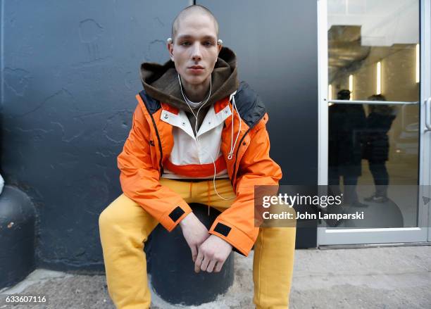 Guest is seen wearing a orange ski jacket, yellow pants and a brown hoodie outside the General Idea fashion show during New York Men's fashion week...