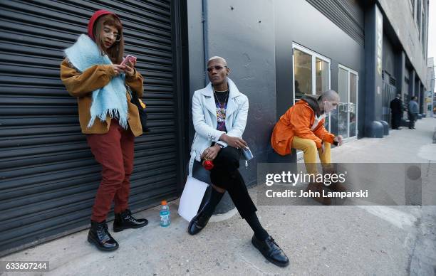 Guests are seen wearing a orange ski jacket, yellow pants, a brown hoodie, blue jacket,T-shirt, scarf and a brown jacket and pants outside the...