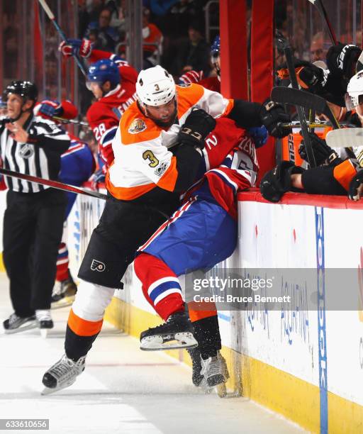 Artturi Lehkonen of the Montreal Canadiens is hit into the boards by Radko Gudas of the Philadelphia Flyers during the first period at the Wells...