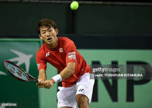 Yoshihito Nishioka of Japan hits a return against Gilles Simon of France during their Davis Cup tennis world group first round second match between...