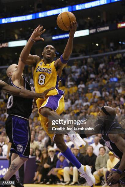Kobe Bryant of the Los Angeles Lakers goes to the basket past Mike Bibby of the Sacramento Kings in Game four of the Western Conference Finals during...