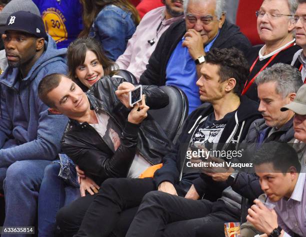 Alison Brie, Dave Franco and James Franco attend a basketball game between the Golden State Warriors and Los Angeles Clippers at Staples Center on...