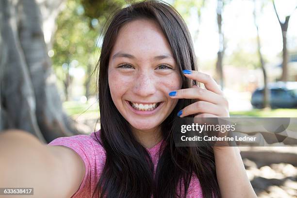 teen girl with blue nails taking a happy selfie - sourire à pleines dents photos et images de collection