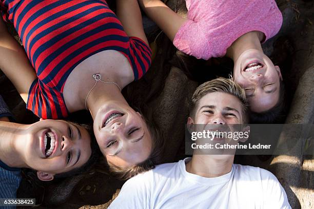 overhead shot of 4 teens laughing - dark hair roots stock pictures, royalty-free photos & images
