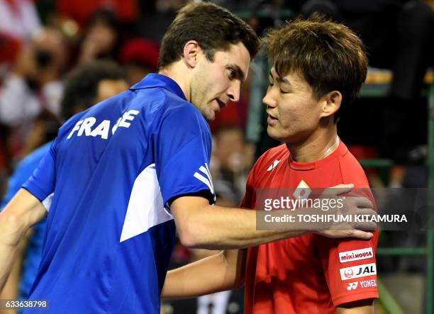Gilles Simon of France speaks with Yoshihito Nishioka of Japan after their Davis Cup tennis world group first round second match between Japan and...