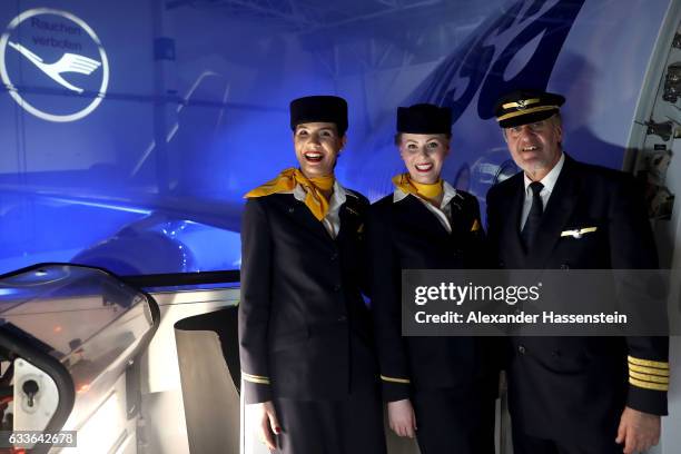 Airhostesses and a pilot of German airline Lufthansa stands a the main door of Lufthansa's first Airbus A350-900 passenger plane during a roll-out...