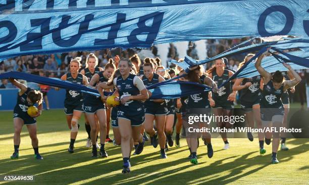 Lauren Arnell of the Blues leads her team through the banner during the 2017 AFLW Round 01 match between the Carlton Blues and the Collingwood...