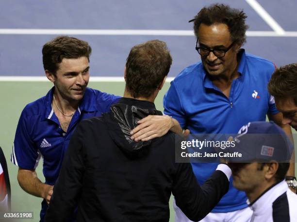 Gilles Simon and captain of Team France Yannick Noah greet teammates following Gilles' victory against Yoshihito Nishioka of Japan on day 1 of the...