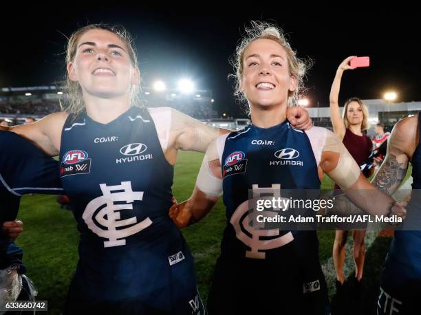 Madeline Keryk and Lauren Arnell of the Blues sing the team song during the 2017 AFLW Round 01 match between the Carlton Blues and the Collingwood...