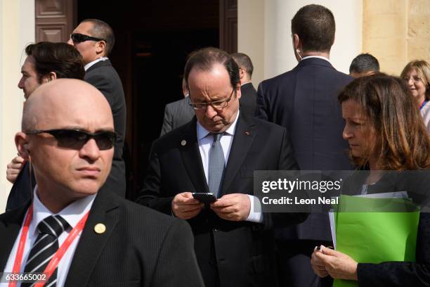 President of France Francois Hollands checks his phone between photo calls at the Malta Informal Summit on February 3, 2017 in Valletta, Malta....