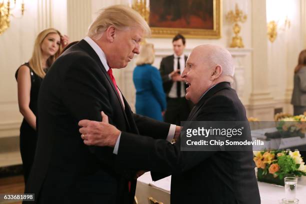 President Donald Trump greets former General Electric CEO Jack Welch at the beginning of a policy forum in the State Dining Room at the White House...