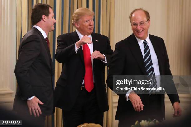 President Donald Trump greets Wal-Mart Stores CEO Doug McMillon and BlackRock CEO Larry Fink at the beginning of a policy forum in the State Dining...