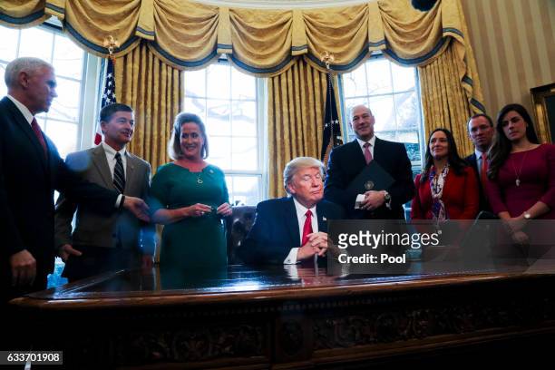 President Donald Trump pauses as he signs Executive Orders in the Oval Office of the White House, including an order to review the Dodd-Frank Wall...