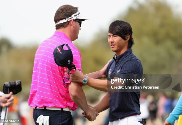 Ryo Ishikawa of Japan shakes hands with Charlie Beljan on the ninth green following the second round of the Waste Management Phoenix Open at TPC...