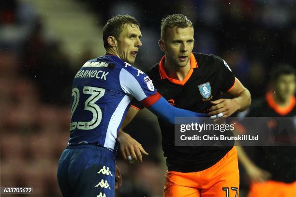 Stephen Warnock of Wigan Athletic grapples with Jordan Rhodes of Sheffield Wednesday during the Sky Bet Championship match between Wigan Athletic and...