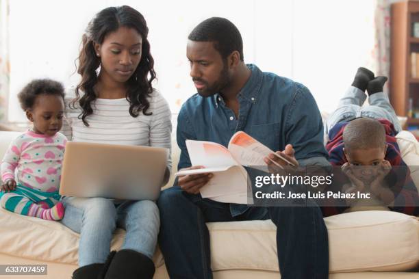 stressed parents paying bills on laptop - american red cross fotografías e imágenes de stock