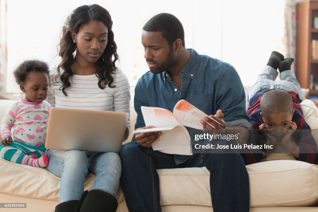 Stressed parents paying bills on laptop