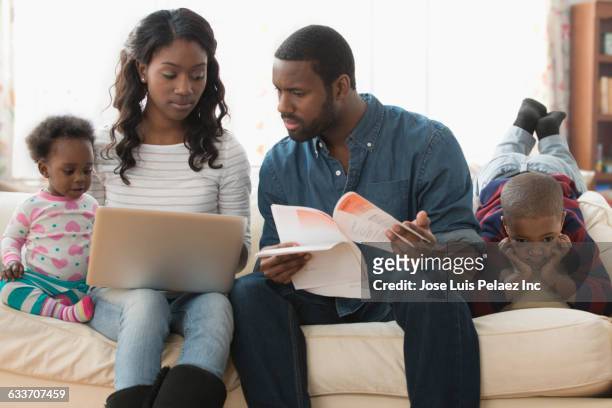 stressed parents paying bills on laptop - fish out of water stock pictures, royalty-free photos & images