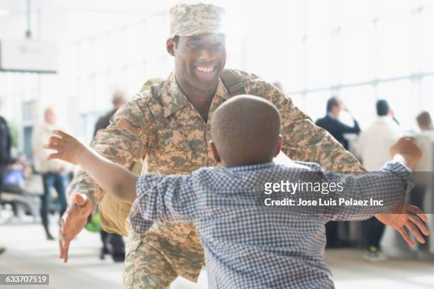 returning soldier hugging son - army soldier family stock pictures, royalty-free photos & images