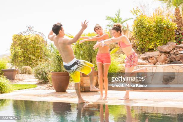 women pushing man into swimming pool - summer press day ストックフォトと画像