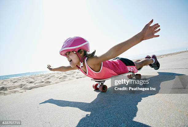 girl riding skateboard at beach - one girl only stock pictures, royalty-free photos & images