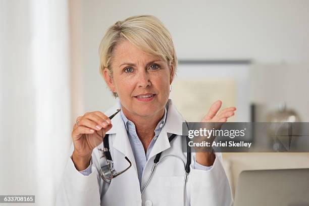 caucasian doctor talking in office - doctor gesturing stock pictures, royalty-free photos & images